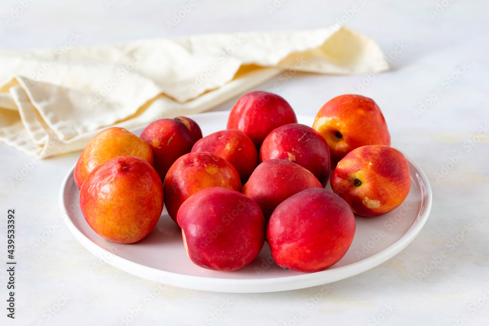 Ripe fresh nectarine on a white ceramic plate Ripe fresh nectarine on a white ceramic plate
