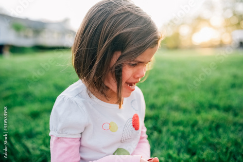 Little girl crying in the front yard. 