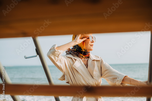 Woman holding sunglasses while looking far away photo