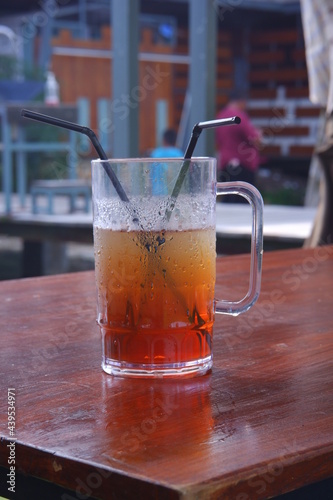 a glass of iced tea with straw