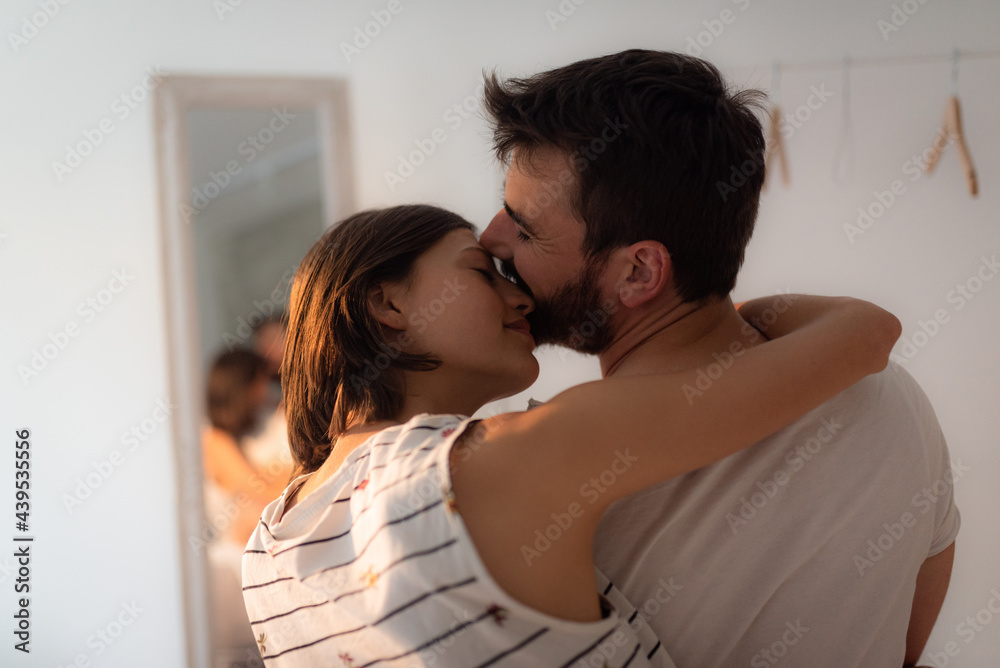Young couple kissing and cuddling while siting on the bed. Young couple kissing and cuddling while siting on the bed.