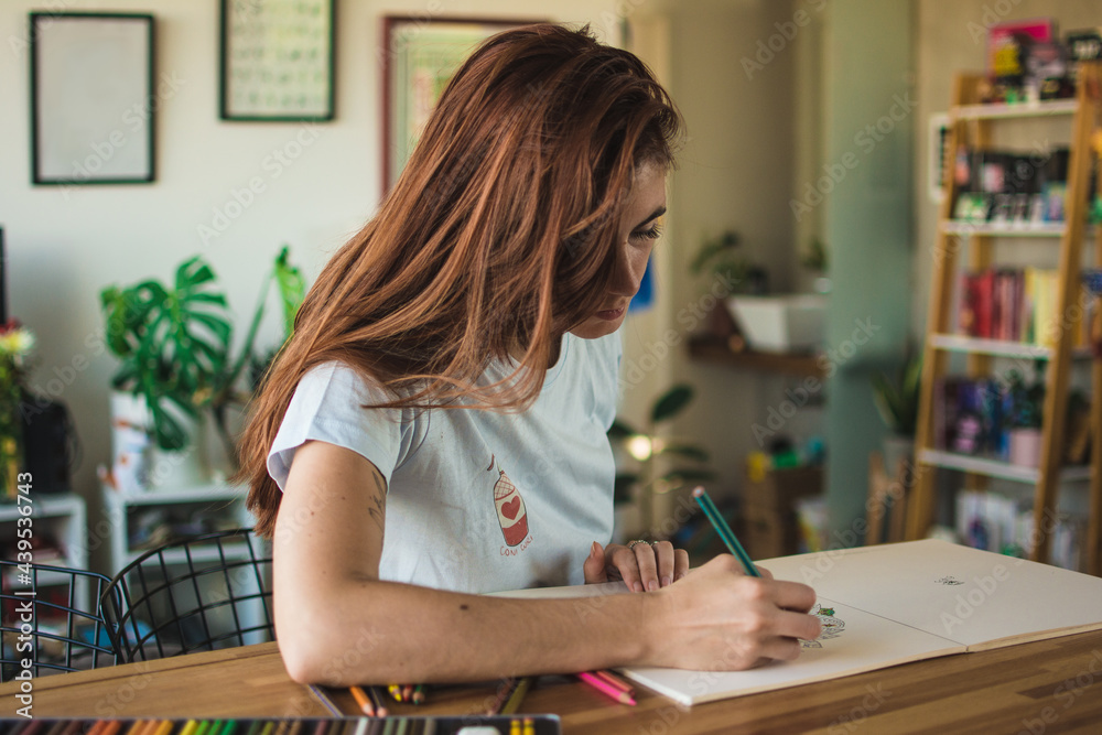 Red haired woman coloring a book Red haired woman coloring a book