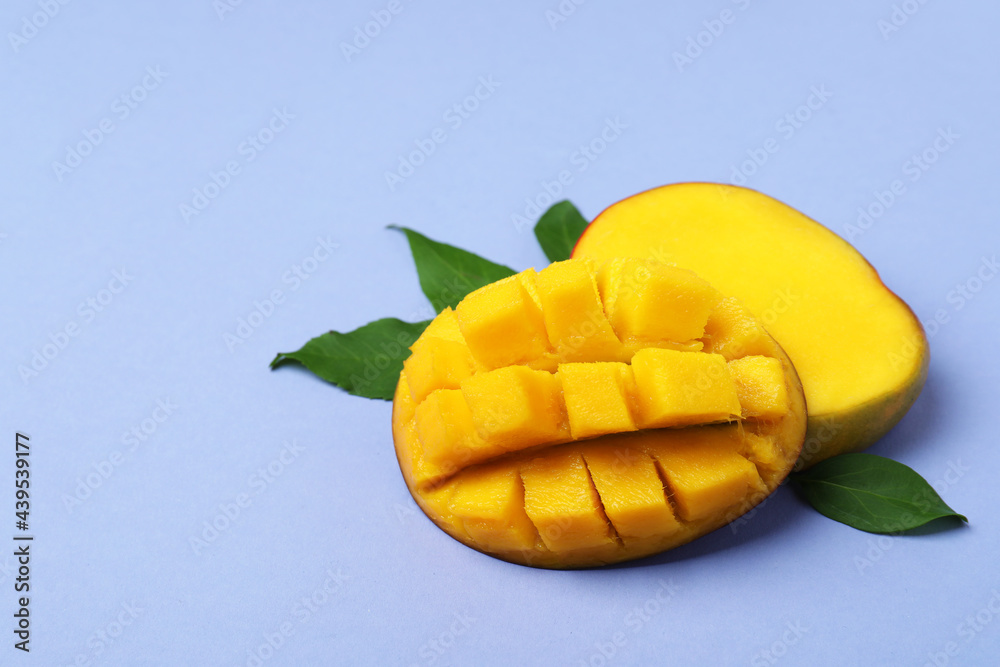 Tasty ripe mango fruit on violet background