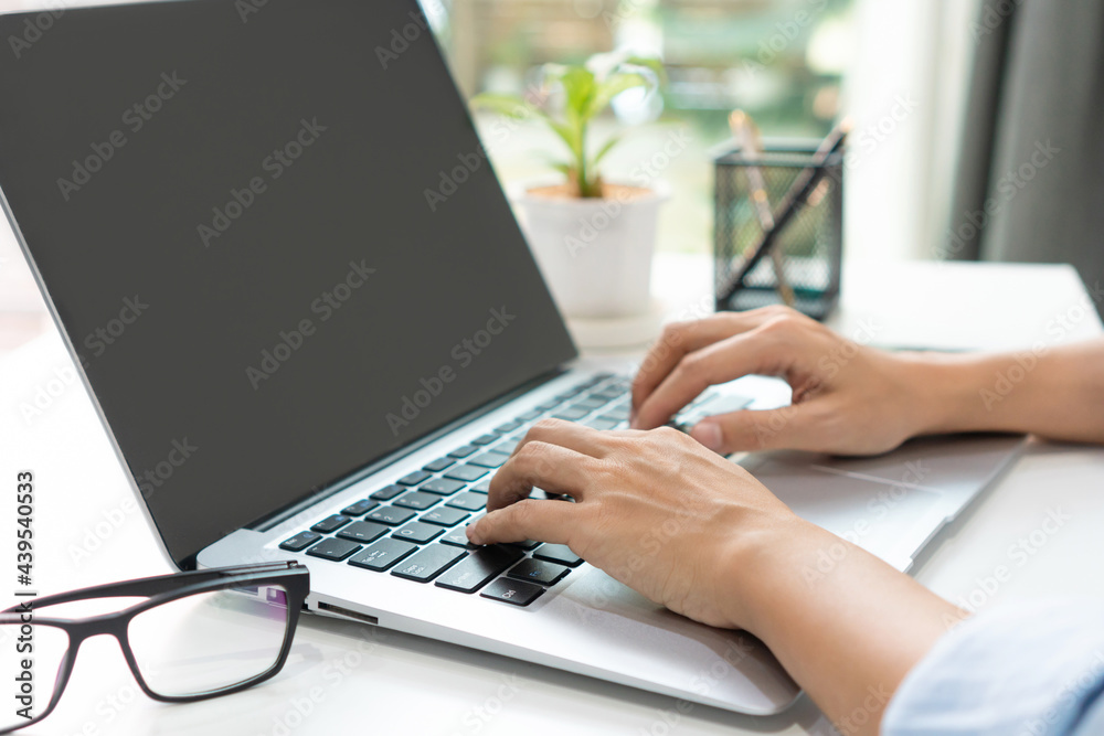 Asian woman freelancer is working on a new project on laptop computer with blank copy space screen for your advertising text message at home. Work from home, business and technology concept. Closeup Asian woman freelancer is working on a new project on laptop computer with blank copy space screen for your advertising text message at home. Work from home, business and technology concept. Closeup