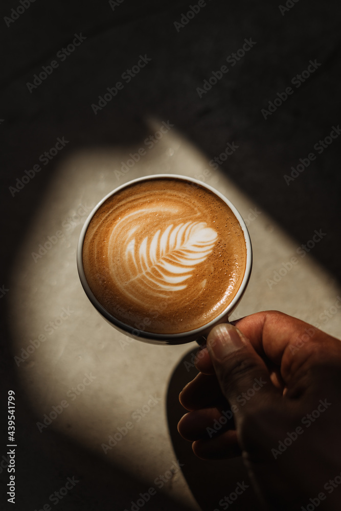 A cup of Coffee latte on the Cement floor in sunlight A cup of Coffee latte on the Cement floor in sunlight