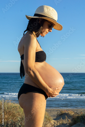 Portrait of a young pregnant woman sunbathing on the beach photo