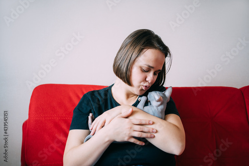 Woman hugging kitten at home photo
