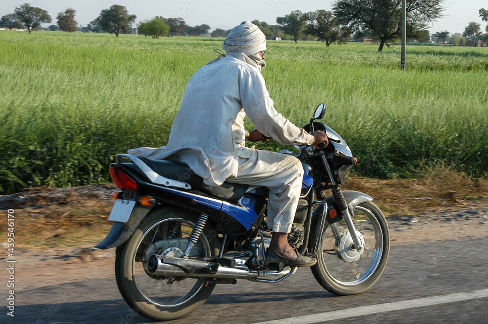 Campesino circulando en motocicleta por una carretera de Rajastán en India Campesino circulando en motocicleta por una carretera de Rajastán en India