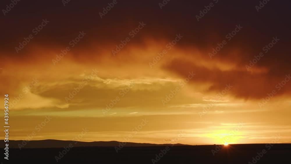 Colorful Wyoming sunset as cars move across the sun on the horizon in timelapse. Colorful Wyoming sunset as cars move across the sun on the horizon in timelapse.