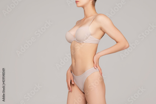 Perfect slim toned young body of the girl or fit woman at studio. The fitness, diet, sports, plastic surgery