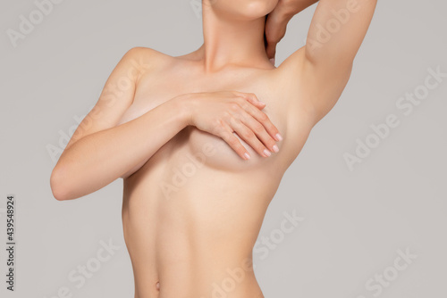 Cropped portrait of young, slim, healthy and beautiful woman isolated over gray background. photo