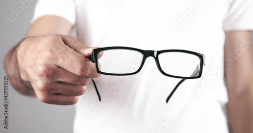 Caucasian professional doctor showing eyeglasses.