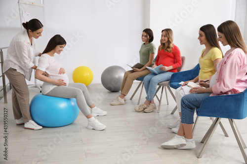 Group of pregnant women with midwife at courses for expectant mothers indoors photo