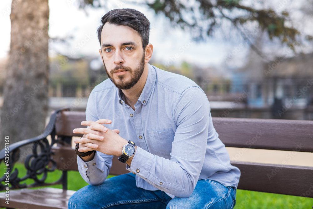Obraz premium Portrait of a man who sits on a bench and thinks