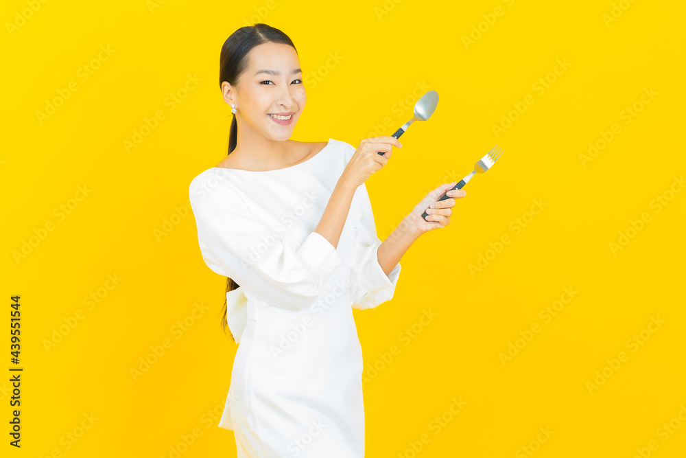 Portrait beautiful young asian woman smile with spoon and fork Portrait beautiful young asian woman smile with spoon and fork