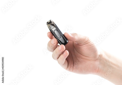 The hand holds a black electronic cigarette. Close up. Isolated on a white background