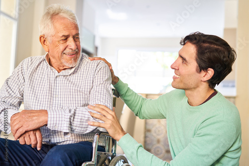 Fürsorglicher Mann kümmert sich um Senior Vater im Rollstuhl