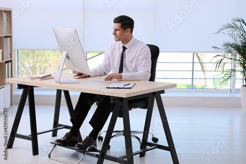 Obraz na płótnie Man using footrest while working on computer in office