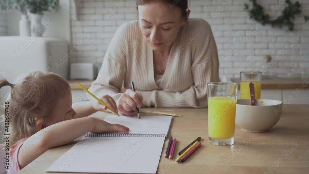 mother and daughter drawing during breakfast in kitchen mother and daughter drawing during breakfast in kitchen