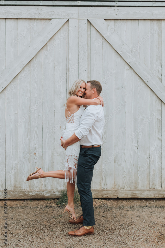 Groom Picking up Happy Bride in front of Barn Groom Picking up Happy Bride in front of Barn
