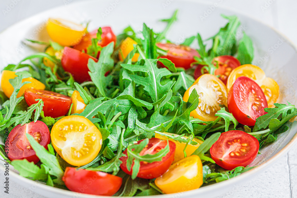 Arugula and tomatoes salad. Healthy vegan food concept. Arugula and tomatoes salad. Healthy vegan food concept.