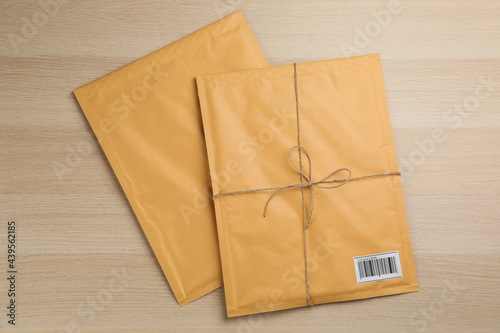 Padded envelopes on wooden background, flat lay