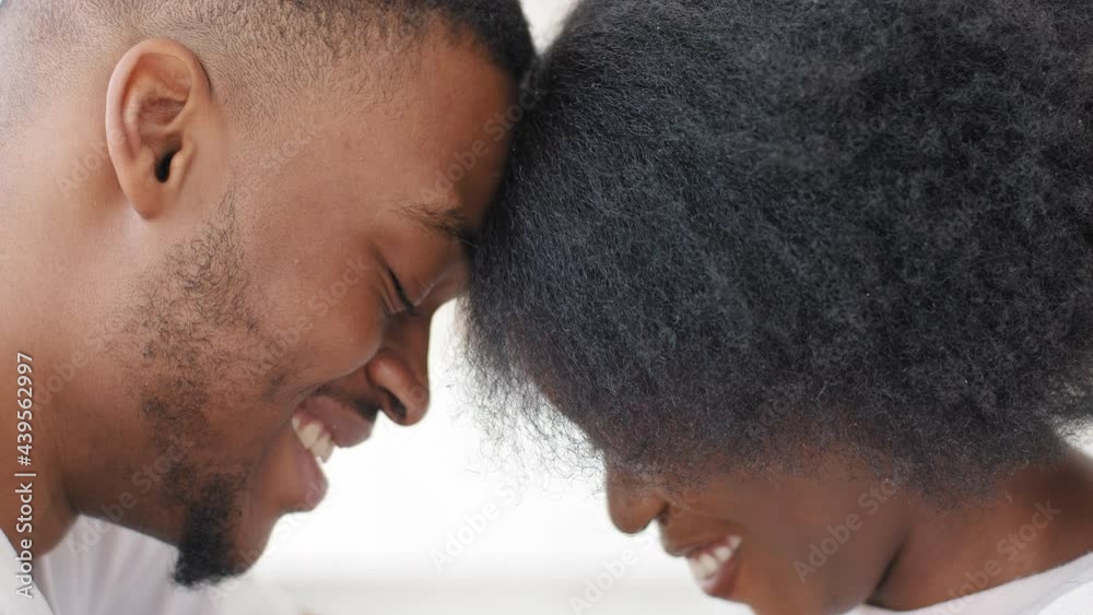 Young afro american married couple newlyweds african ethnic man and millennial curly woman lovers boyfriend and girlfriend sitting at home with foreheads touched smile talk enjoy intimacy relationship Young afro american married couple newlyweds african ethnic man and millennial curly woman lovers boyfriend and girlfriend sitting at home with foreheads touched smile talk enjoy intimacy relationship