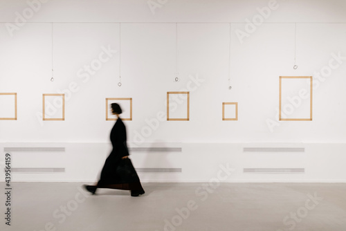 defocused woman walking in exhibition art hall photo