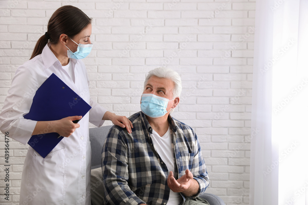 Doctor taking care of senior woman in protective mask at nursing home Doctor taking care of senior woman in protective mask at nursing home