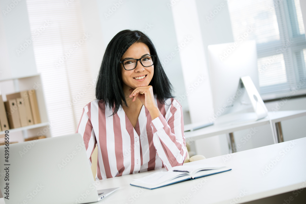 Portrait of a business woman with glasses at workplace in office Portrait of a business woman with glasses at workplace in office