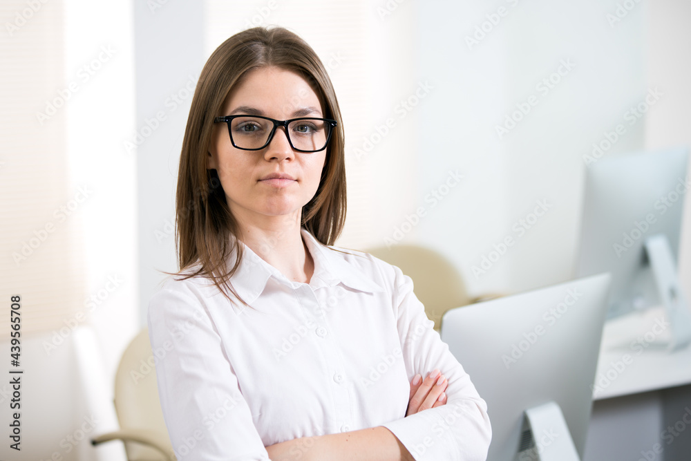Portrait of business woman looking at camera at workplace in an office Portrait of business woman looking at camera at workplace in an office