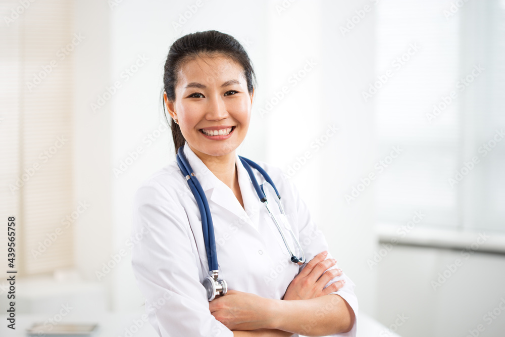 Portrait of smiling asian female doctor in a gray background for your text. Portrait of smiling asian female doctor in a gray background for your text.