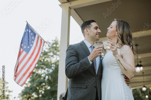 Bride and Groom Drinking Champagne on Porch photo