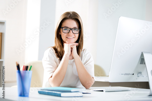 Portrait of business woman looking at camera at workplace in an office