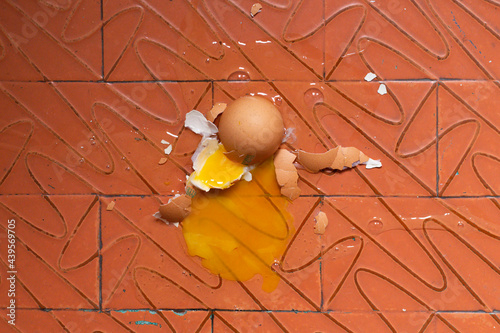 broken egg on red dirty rustic floor