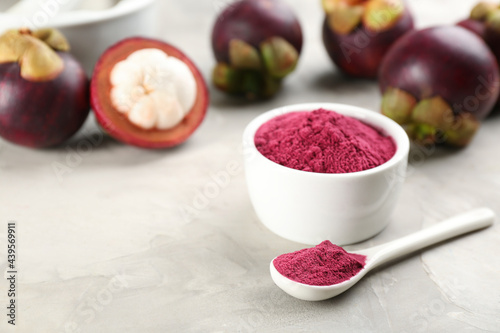 Fototapeta Naklejka Na Ścianę i Meble -  Purple mangosteen powder and fruits on light grey table