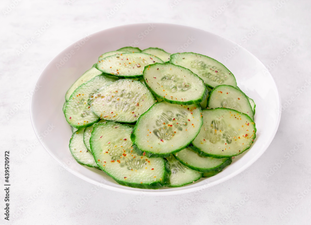 Fresh cucumber salad in bowl on white background