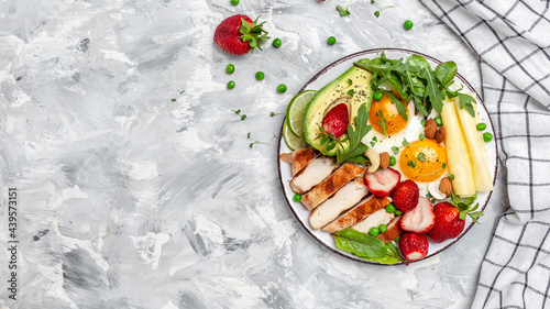 keto ketogenic diet Fried egg, avocado, strawberry, grilled chicken fillet, cheese, nuts and arugula, Ketogenic diet. Low carb high fat breakfast, top view