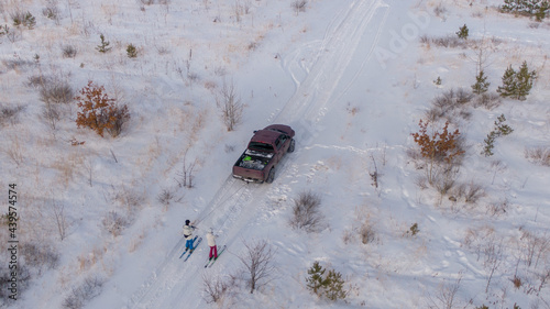 Winter fun: couple riding ski towed  to the car photo