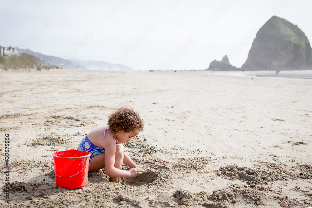 Girl digs in sand by on Cannon Beach
Girl digs in sand by on Cannon Beach