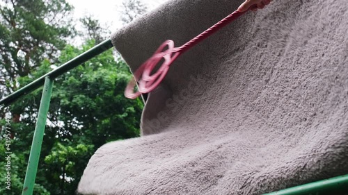 Cleaning Carpet with Cheap Carpetbeater on Outdoor Public Carpet Hanger Creating Clouds of Dust and Dirt Slow Motion photo