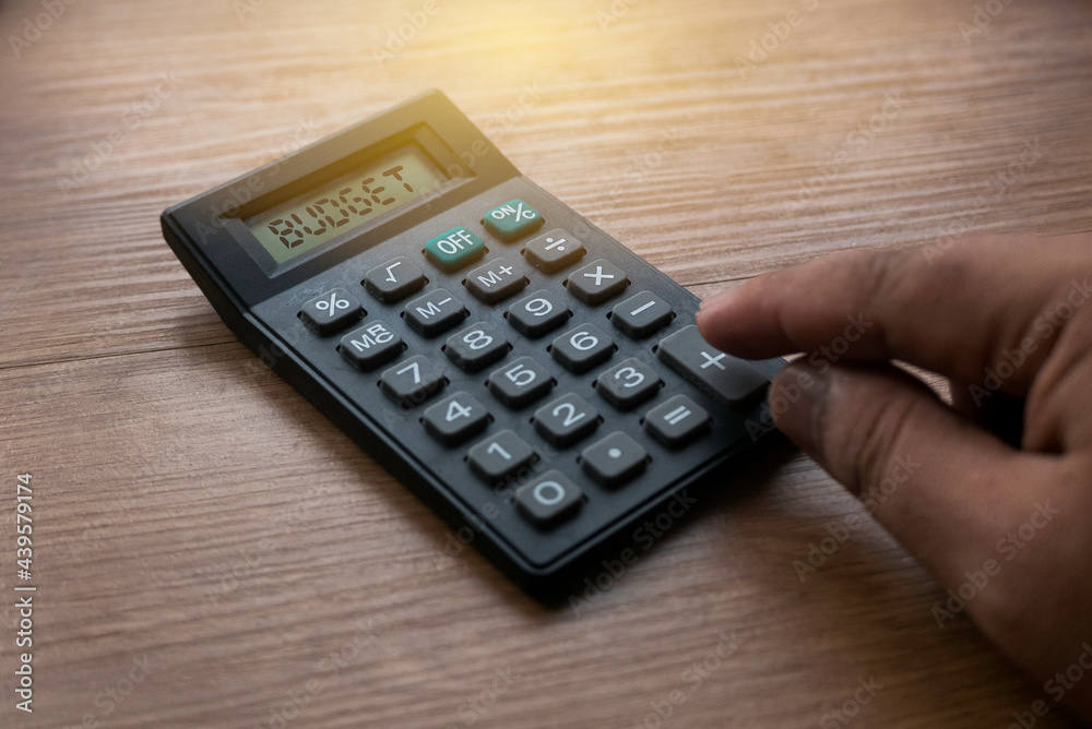 Business and finance concept. Finger press calculator button with word BUDGET on display. Business and finance concept. Finger press calculator button with word BUDGET on display.
