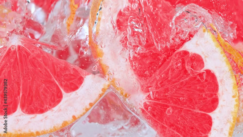 Super Slow Motion Shot of Pouring Water on Grapefruit Slices and Ice Cubes in Glass at 1000 fps. Super Slow Motion Shot of Pouring Water on Grapefruit Slices and Ice Cubes in Glass at 1000 fps.