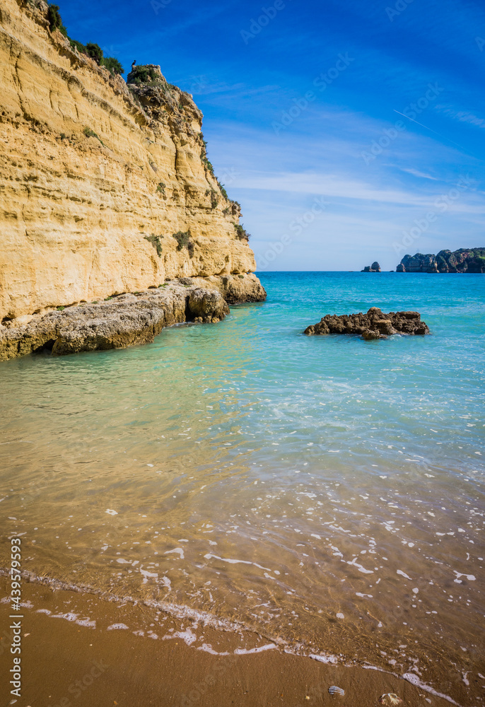 Cliffs of Praia da Dona Ana, sandy beach with clear blue water on a sunny day, no people, Lagos, Algarve, Portugal