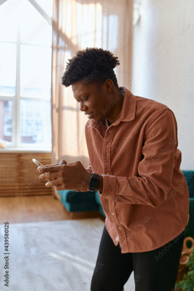 black man chatting online smartphone at home