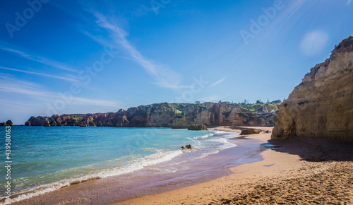 Praia da Dona Ana Beach, sandy beach with clear blue water between cliffs on a sunny day, no people, Lagos, Algarve, Portugal