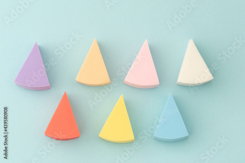 Colourful makeup sponges triangular  shape on a gentle blue background