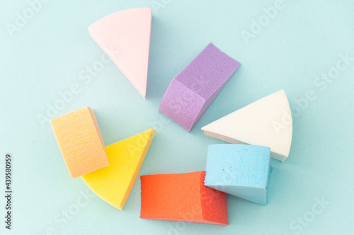 Colourful makeup sponges triangular shape on a gentle blue background