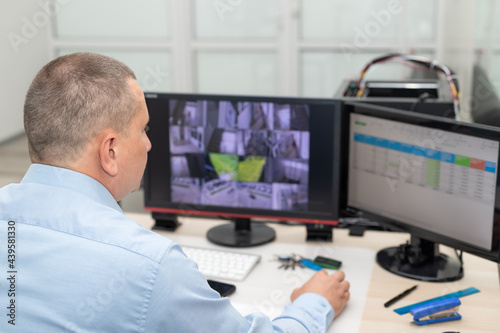 Security guard monitoring CCTV cameras in security room. Surveillance, modern technology concept. selective focus