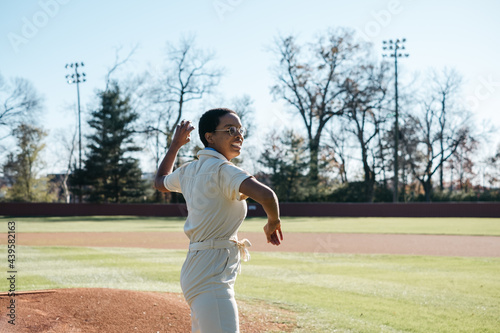 Young woman pitching a baseball